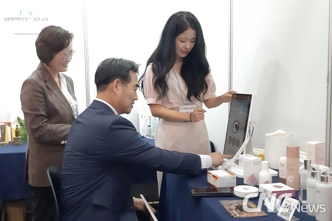 대한화장품산업연구원 부스에서 이성권 경제부지사가 피부 진단 및 맞춤형 화장품 과정을 체험하고 있다. 왼쪽은 대한화장품산업연구원 이재란 원장.
